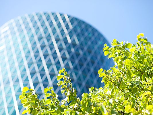 Skyscraper facade with green trees