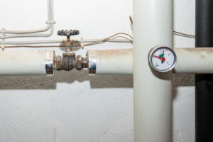 Heizungsanlage für Fernwärme in einem Altbau. Rohre mit Apsterrventil und Gradmesser