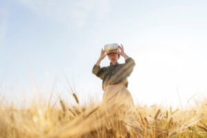 Businesswoman with virtual reality simulator standing in field.