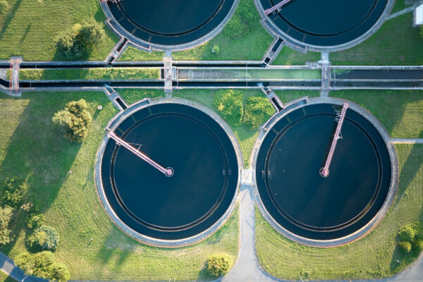 Aerial view of wastewater treatment plant with settling tanks.